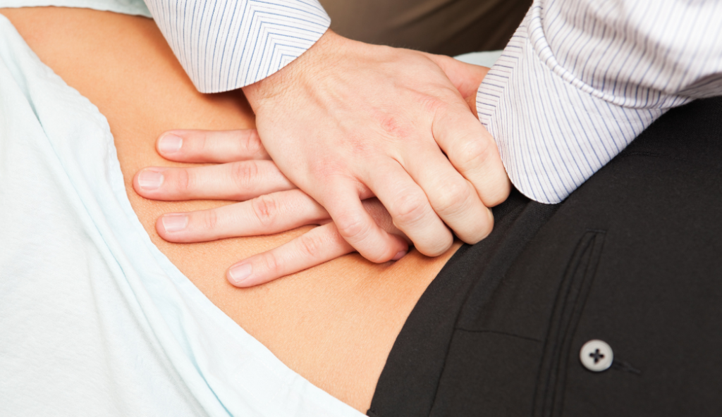 Chiropractor pressing on lower back