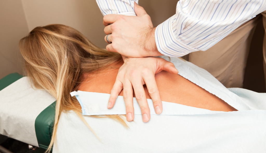 Chiropractor fixing woman's back