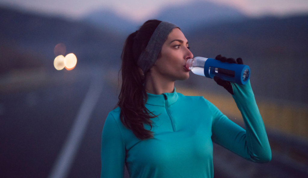 Female athlete hydrating herself after a run